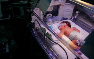 Premature little baby in an incubator at the neonatal section of the maternity